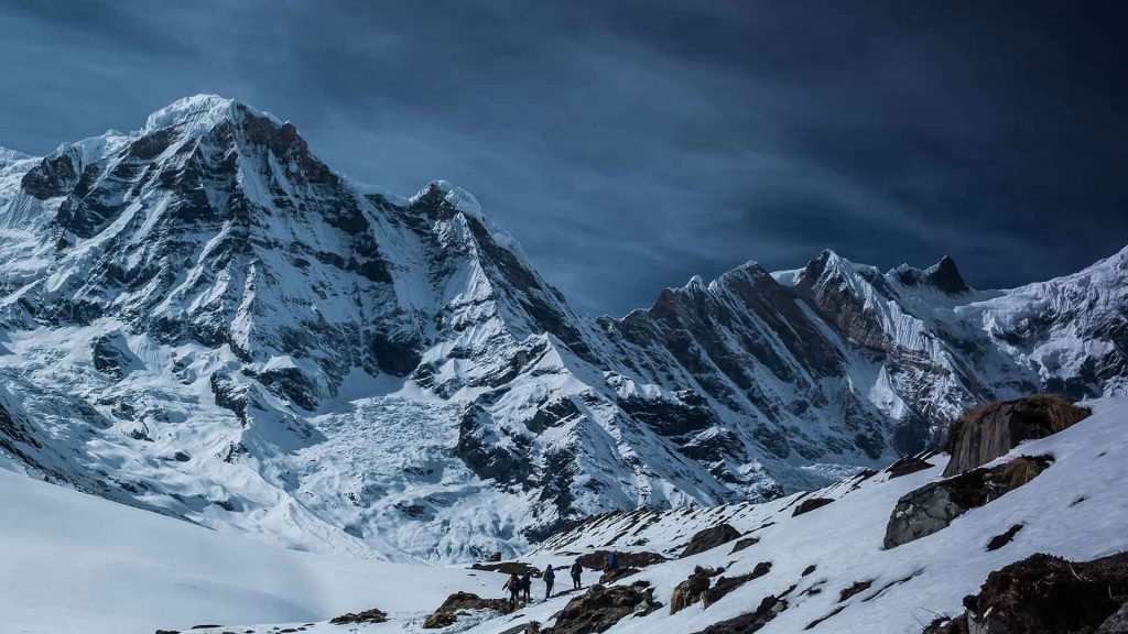 People Standing at the Base of a Mountain